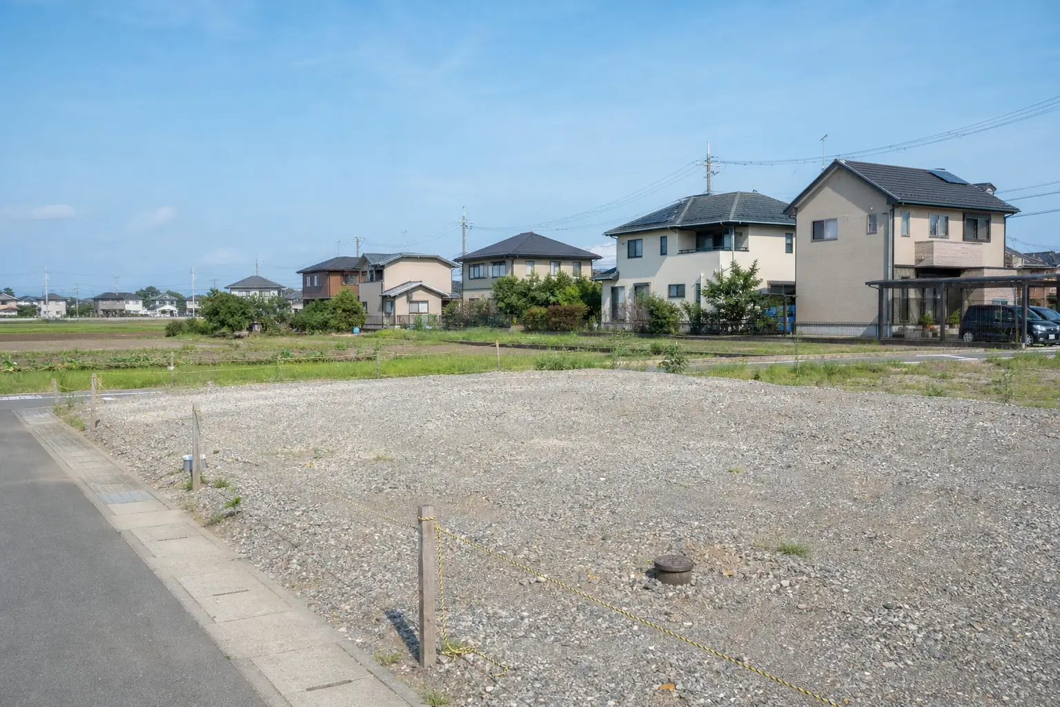 市街化調整区域の田畑のそばにある空き地と、まばらに建つ住宅の写真