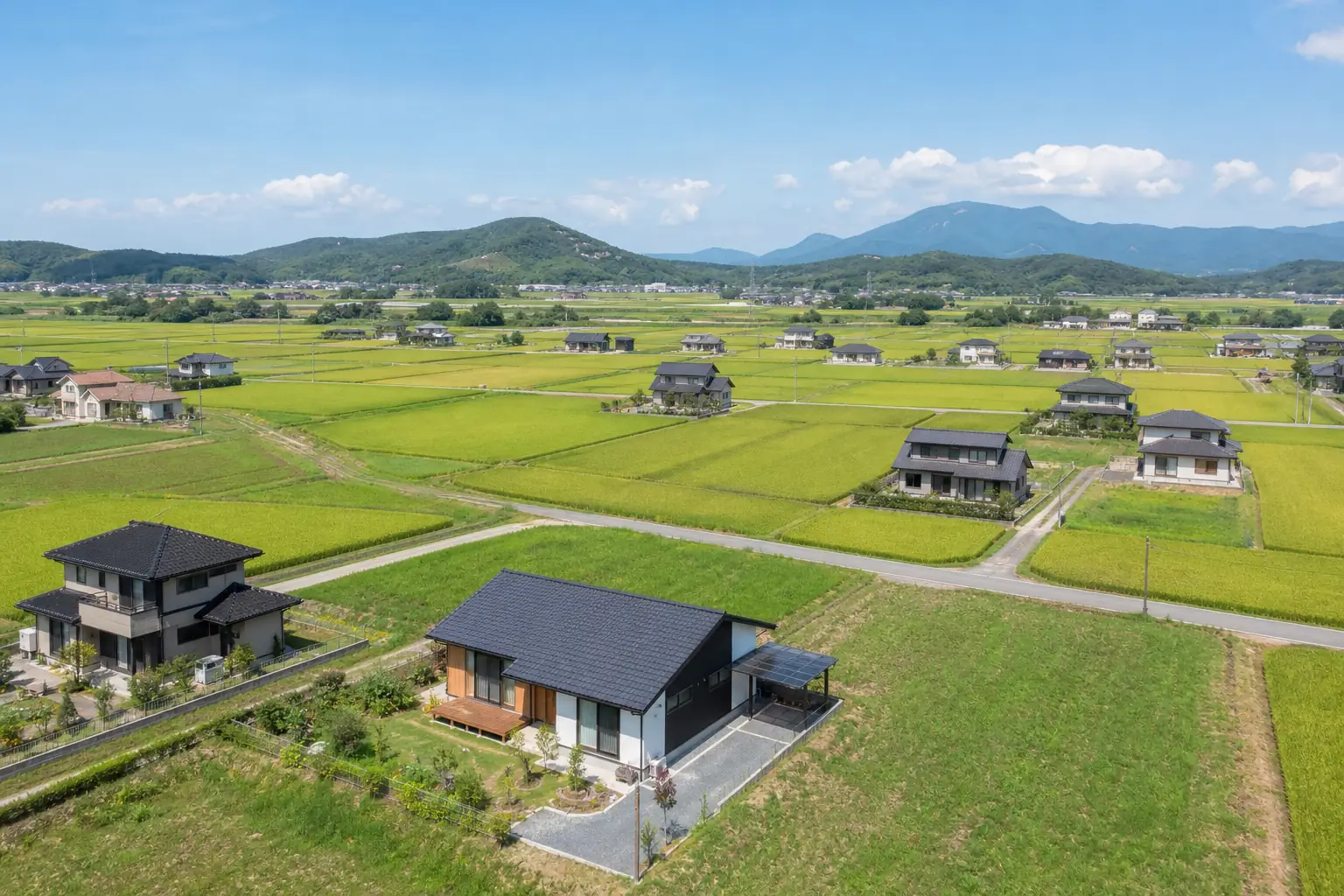 用途地域の指定のない区域のイメージとして、田畑の間に一戸建てが点在する郊外の風景