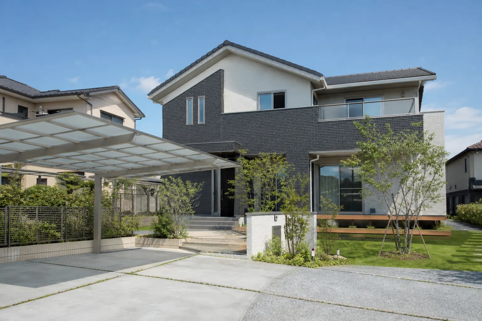 建ぺい率50％の土地で、敷地の半分を庭と駐車場として残して建てた2階建ての家の外観
